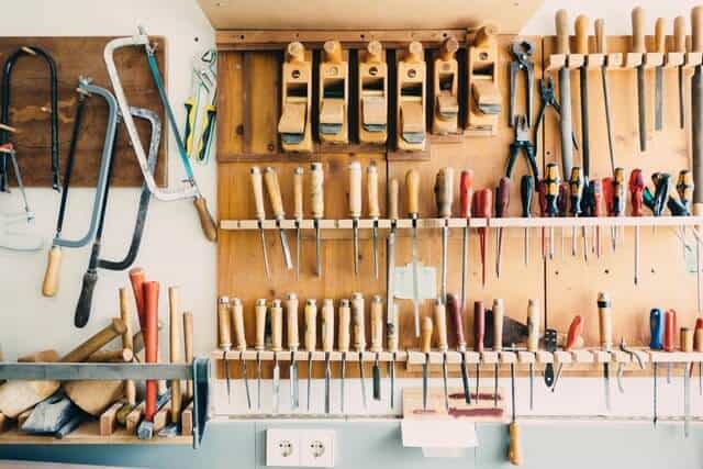 photo of a wall mounted pegboard with clean woodworking tools on it.