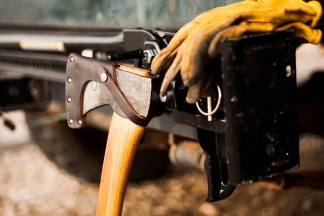 photo of a tool belt with an axe and safety gloves on it