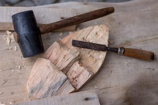 photo of a mallet and chisel used for carving wood.