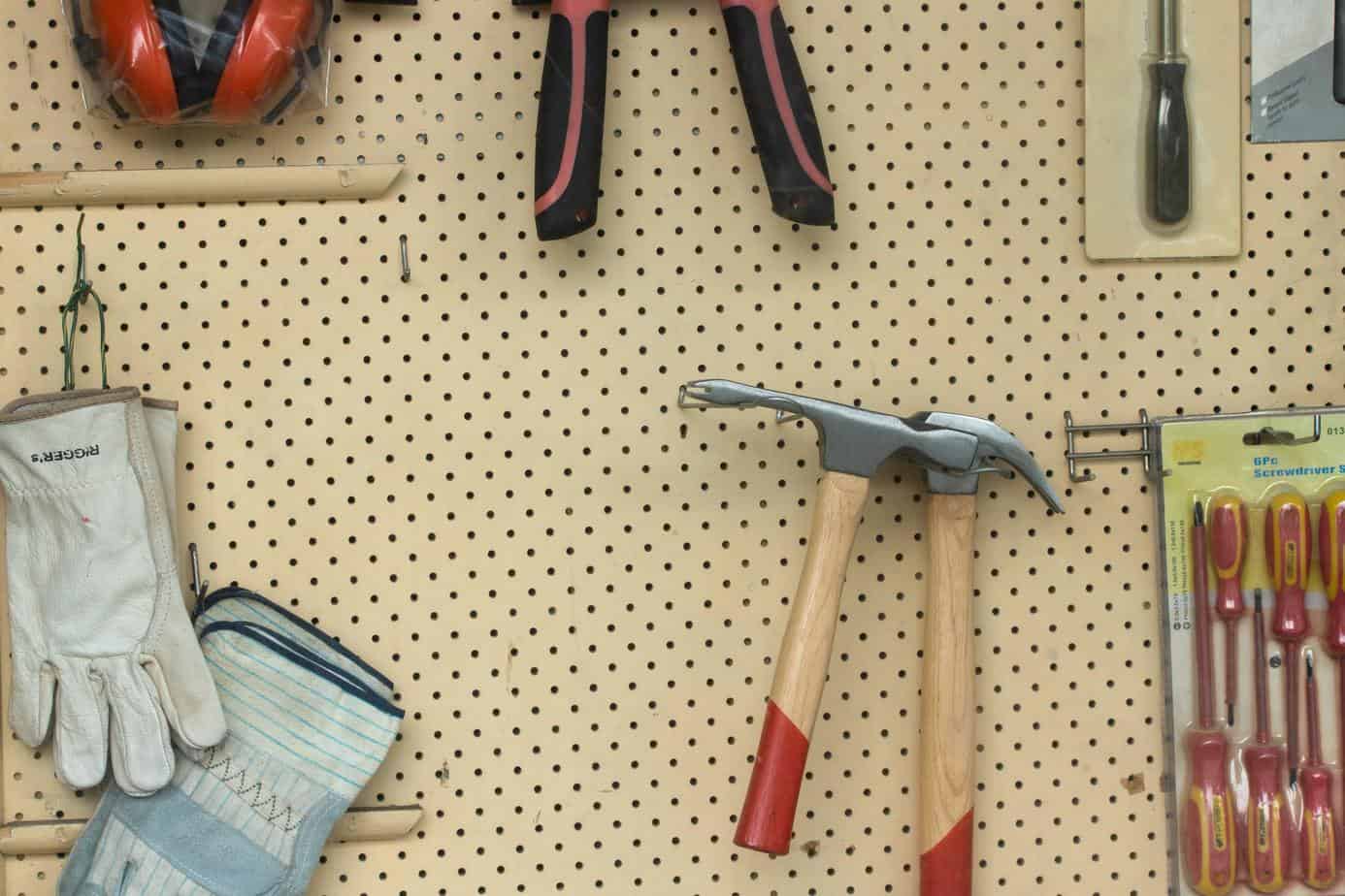 photo of a wall mounted pegboard with clean woodworking tools on it.