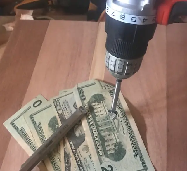 picture of a drill with a forstner bit and money