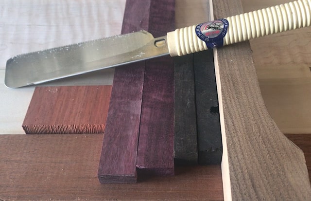 Photo of a Dozuki Hand saw sitting on purpleheart wood